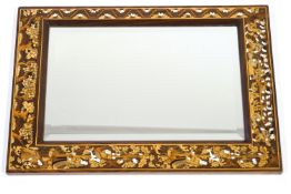 A wall mirror with decorative marquetry and penwork frame with figures climbing a tree,