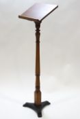 A pine lectern on turned support and triform cast iron base,