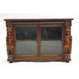 A carved oak cabinet with two glazed doors,