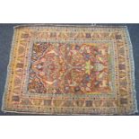 An antique Persian rug with central panel of a vase with flowers and birds,
