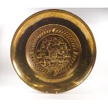 A brass alms dish, embossed to the centre with the grape carriers,