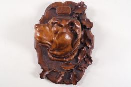 A 19th century Swiss carved wall plaque, the centre carved with a dogs head, titled 'Cesar',