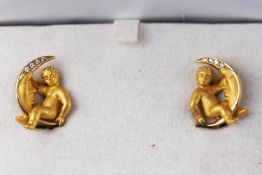 A yellow gold pair of Carrera Y Carrera earrings stylized as a cherub with a moon,