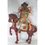 A large Japanese pottery group of a figure on a horse, decorated with multi coloured glazes,