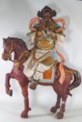 A large Japanese pottery group of a figure on a horse, decorated with multi coloured glazes,