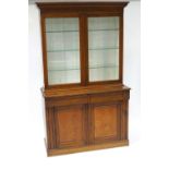 An early 20th century oak glazed bookcase on cupboard base,