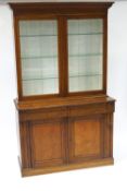 An early 20th century oak glazed bookcase on cupboard base,