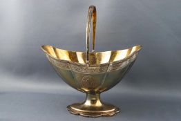 A George III silver swing handled sugar basket with bright cut decorated lobed body