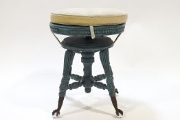 A piano style stool with upholstered cushion on blue painted legs with metal claw feet,