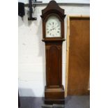 An 18th century oak long case clock with white painted arched dial to pillared hood enclosing an