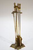 A set of three brass fire irons, on stand,