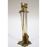 A set of three brass fire irons, on stand,