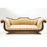 A Regency/Empire mahogany recamier style sofa with scroll end terminals and shaped back over a