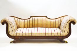 A Regency/Empire mahogany recamier style sofa with scroll end terminals and shaped back over a