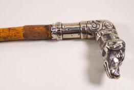 A walking stick with white metal dogs head,