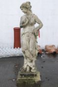 A composite stone garden statue in the form of a classical maiden on square plinth,