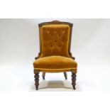 A Victorian nursing chair with carved mahogany show frame,