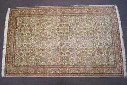 A fine silk Mauritian carpet with a cream floral central panel in a similarly decorated pink border,