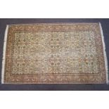 A fine silk Mauritian carpet with a cream floral central panel in a similarly decorated pink border,