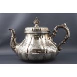 A silver baluster tea pot with panelled body, highlighted with strap work engraving, London 1873,