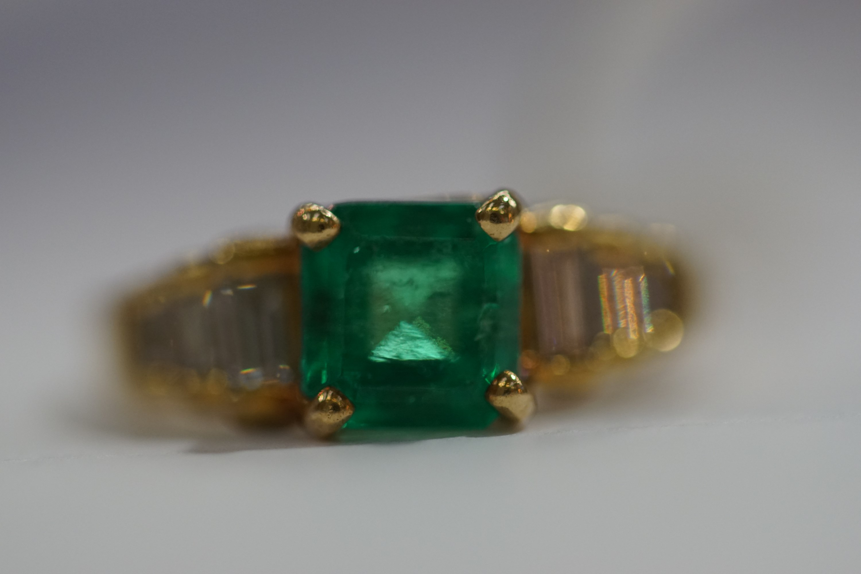 A yellow metal dress ring set with a square emerald together with baguette cut diamond shoulders. - Image 2 of 3