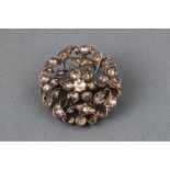 A George III floral diamond brooch set with a central old cut diamond and surrounded by rose cut