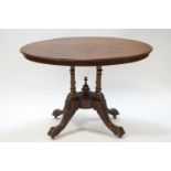 A walnut loo table on carved pedestal and legs,