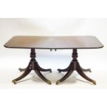 A solid mahogany twin pedestal dining table with two leaves,