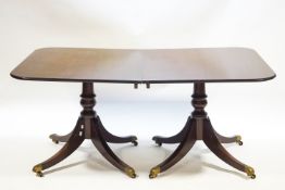 A solid mahogany twin pedestal dining table with two leaves,
