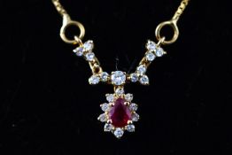 A yellow metal centrepiece necklace set with a pear cut ruby and surrounded by diamonds.