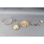 A collection of jewellery to include a seed pearl brooch, a silver charm bracelet,