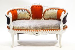 A small painted carved wood sofa with curved ends,