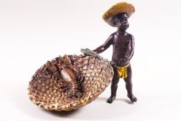 A cold painted bronze figure of a young boy holding a fish with a lobster in a basket,
