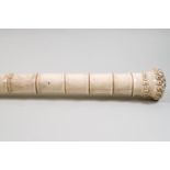 A walking cane, the shaft made from bone and carved to resemble a bamboo cane.