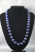 A single strand of round uniform lapis lazuli beads, measuring from 14.0mm to 15.0mm.