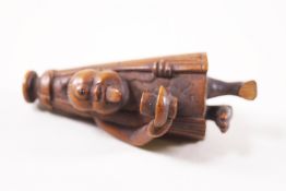 A Japanese carved wood figure of a netsuke in the form of a man holding a bowl.