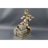 A silver and gilt money box in the form of 'The fiddler on the roof', 16cm high,