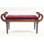 A William IV mahogany window seat, with carved and turned scroll ends on turned tapering legs,