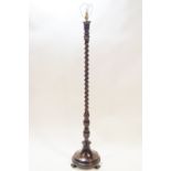 A mahogany standard lamp on barley twist and reeded baluster support with round base