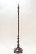 A mahogany standard lamp on barley twist and reeded baluster support with round base