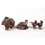 Two cold painted metal figures of pheasants, a rabbit and an otter on agate base,