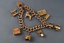 A yellow metal curb link bracelet with padlock and safety chain, fitted with eight assorted charms.