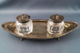 A navette shaped silver dish with with two silver covered ink bottles