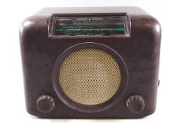 A Bakelite cased Bush radio, the front with central speaker and two control knobs.