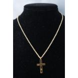 A yellow metal cross pendant,