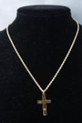 A yellow metal cross pendant,