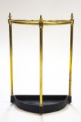 A brass framed umbrella stand of semi-circular form with a cast metal drip tray,