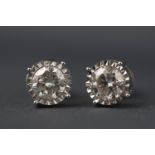 A white metal pair of single stone diamond studs.