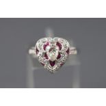 An 18ct white gold Victorian style heart shaped ring set with a central pear cut diamond.