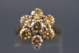 A yellow and white metal seven stone diamond flower ring, Estimated total weight of 2.50 carats.
